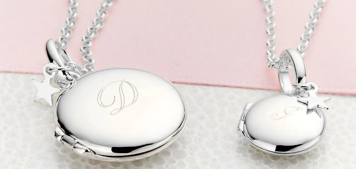 Silver necklaces with pendants on a light pink background