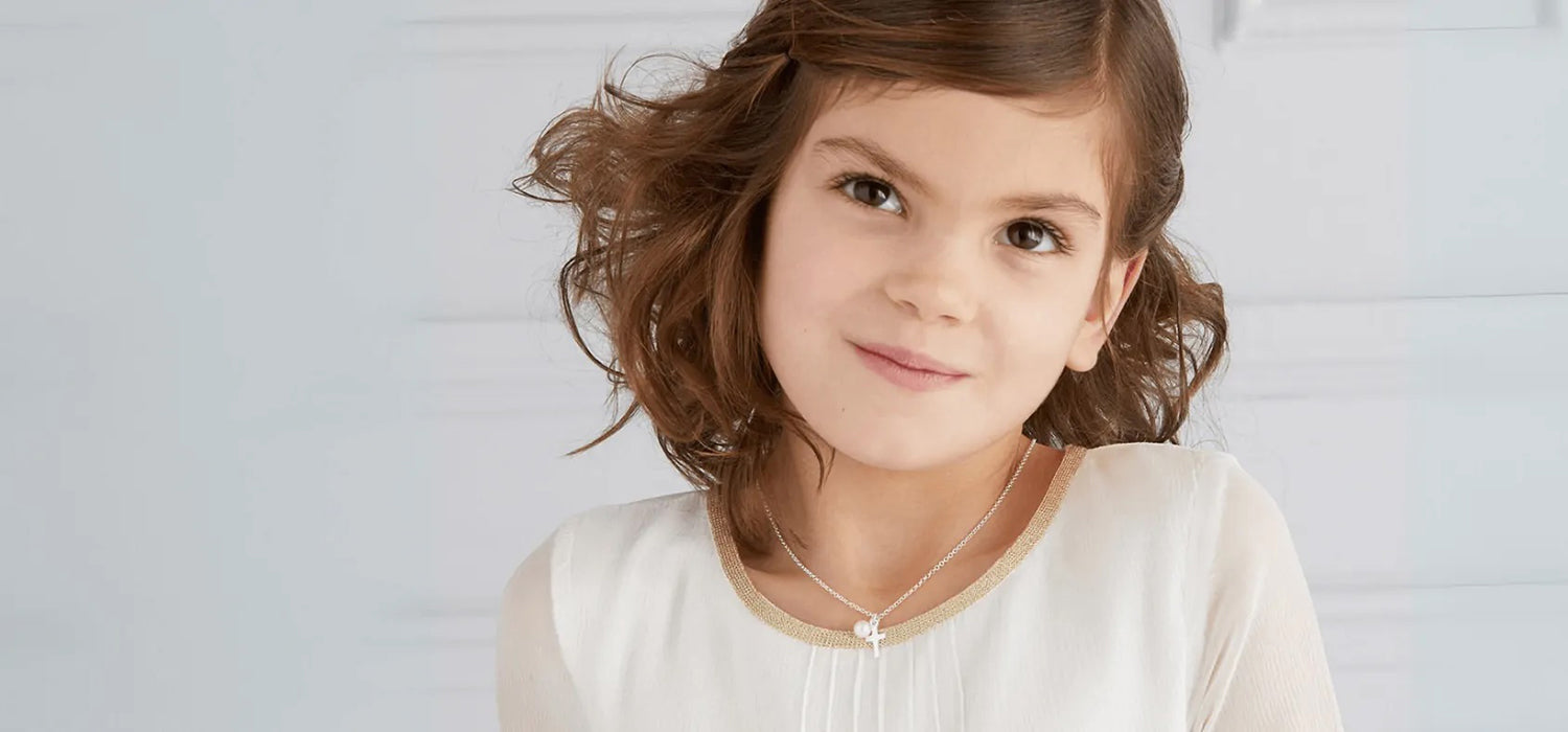 Girl wearing Molly Brown London cross and pearl necklace